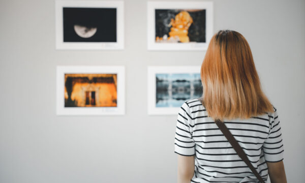 female watch at photo frame to leaning against at exhibit museum Asian young woman standing she looking art gallery in front of colorful framed paintings pictures on white wall, female watch at photo frame to leaning against at exhibit museum, Back view